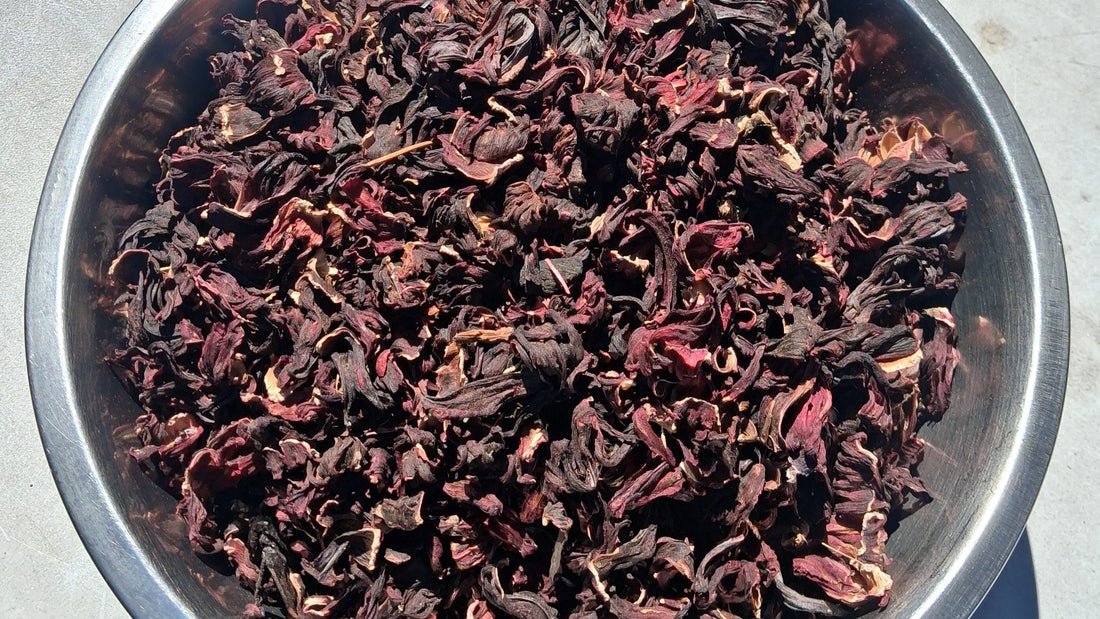 A steel bowl full of whole dried hibiscus calyces, seen from above.